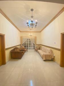 a large living room with couches and a chandelier at Private Cottage in Sharjah