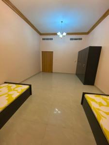 a large room with two beds and a ceiling at Private Cottage in Sharjah