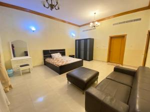 a large living room with a bed and a couch at Holiday Home Rent villa in Sharjah