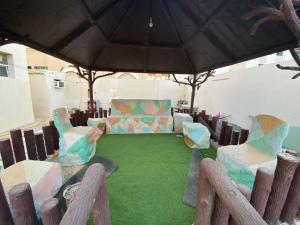 a patio with a table and chairs and an umbrella at Private Cottage in Sharjah