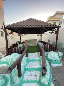a playground with a wooden gazebo in a yard at Private Cottage in Sharjah