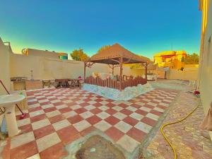 a patio with a gazebo and a table at Private Cottage in Sharjah