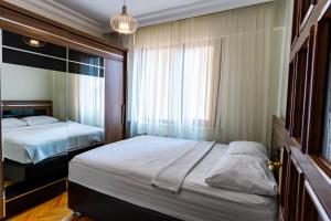 ein Schlafzimmer mit zwei Betten und einem Fenster in der Unterkunft Kaplan Cosy Flat - All air conditioned & Heated 3 Bedrooms in the City in Istanbul