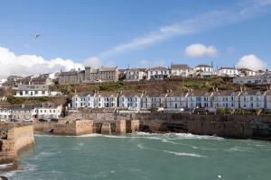 a group of houses on a hill next to a river at The Artist Loft, Ensuite Guest Rooms, Porthleven in Porthleven
