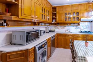 a kitchen with wooden cabinets and a microwave at Kaplan Cosy Flat - All air conditioned & Heated 3 Bedrooms in the City in Istanbul