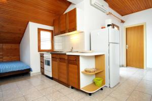a kitchen with a white refrigerator in a room at Apartments with parking space Novalja, Pag - 9419 in Novalja