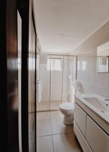 a white bathroom with a toilet and a sink at Quinta Penedo das Antas - AL in Sertã