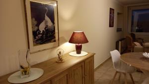 a lamp sitting on top of a wooden cabinet in a room at Au gîte de Binche in Binche