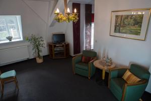 a waiting room with chairs and a table and a tv at Schloss Spiegelberg in Neustadt