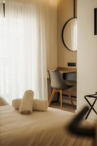 a bedroom with a bed with a chair and a window at ICON Urban Living in Thessaloniki