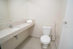 a bathroom with a toilet and a sink at Carandá Hplus Express in Campo Grande
