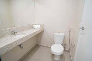 a bathroom with a toilet and a sink at Transamerica Fit Campo Grande in Campo Grande