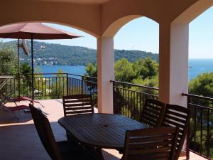 - une terrasse couverte avec une table, des chaises et un parasol dans l'établissement Apartments by the sea Brna - Vinacac, Korcula - 13344, à Prižba