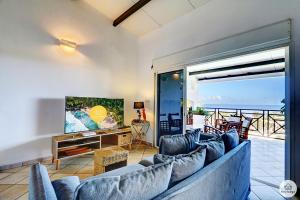 a living room with a couch and a view of the ocean at Villa Horizon Lagon - Piscine chauffée - Vue Mer - 4étoiles - 130m2 - 8p in La Saline les Bains