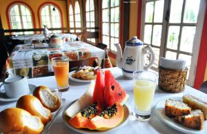 una mesa con platos de comida y vasos de zumo de naranja en Vale Verde Praia Hotel en Porto Seguro
