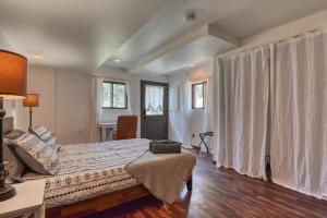 a bedroom with a bed and a desk and windows at Cozy Mountain Cabin in Cascade in Cascade-Chipita Park