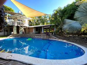 uma grande piscina azul em frente a uma casa em Lote 44 Guesthouse em El Zonte