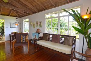a living room with a couch and some windows at Tranquility Villa in Port Antonio