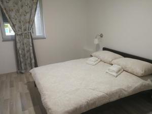 een wit bed met twee handdoeken erop bij Apartment Smoljanac 12345c in Smoljanac