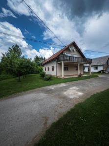 a large white house with a gravel driveway at Apartments with a parking space Smoljanac, Plitvice - 14979 in Smoljanac