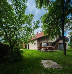 a house with a picnic table and a bench in the yard at Apartments with a parking space Smoljanac, Plitvice - 14979 in Smoljanac