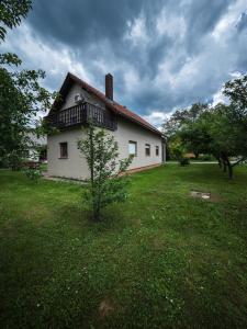 a white house with a tree in the yard at Apartment Smoljanac 14979b in Smoljanac