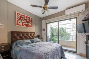 1 dormitorio con 1 cama y ventilador de techo en Departamento semipiso, 2 habitaciones, con parrilla y estacionamiento privado en Buenos Aires