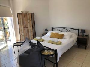 a bedroom with a bed and a table and a chair at Panoramic Holidays - Standard 49 in Peyia