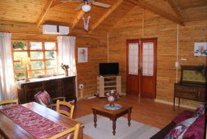 ein Wohnzimmer mit einem Tisch und einem TV in der Unterkunft Fern Cottage in Louis Trichardt