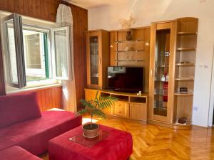 a living room with a red couch and a tv at Apartment Olga in Pučišća
