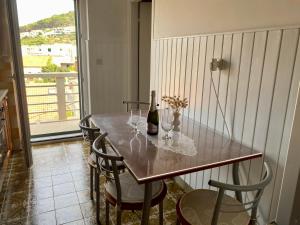 a dining room table with a bottle of wine and chairs at Apartment Olga in Pučišća
