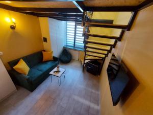 a living room with a couch and a spiral staircase at The Passenger Rooms in Tbilisi City