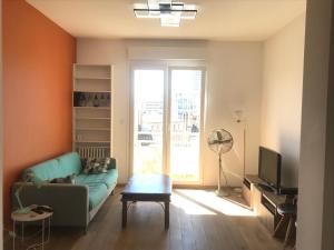 sala de estar con sofá y TV en Très bel appartement T3 proche place Castellane avec vue et 2 chambres en Marsella