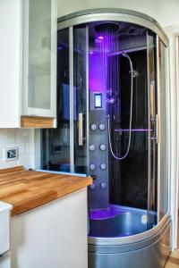 eine Dusche in einer Küche mit lila Beleuchtung in der Unterkunft Wellness Suite Na' Canuna' in Roddi