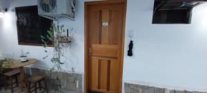 イタイパバにあるPousada da Vilaの木製のドアとテーブルが備わる部屋