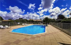 a swimming pool on a patio with a blue sky at Stunning Home In L'aiguillon-Sur-Vie in LʼAiguillon-sur-Vie +11 photos