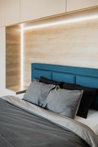 a bed with a blue headboard in a bedroom at Skylark - Singapore Penthouse with Jacuzzi & Panoramic View in Braşov