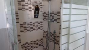 - une douche avec une bouteille noire sur une étagère dans l'établissement il monolocale, à Turin