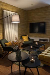 ein Wohnzimmer mit 2 Sofas und einem TV in der Unterkunft Hotel Gewürzmühle in Gera