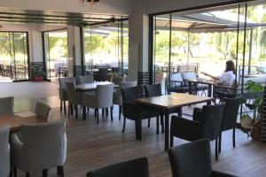 a restaurant with tables and chairs and a woman sitting at a table at ANTİGONİA BUTİK OTEL in İznik