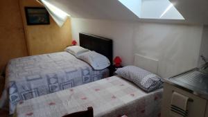 une petite chambre avec deux lits et une fenêtre dans l'établissement il monolocale, à Turin 10 autres photos