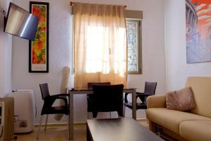 - un salon avec une table et des chaises dans l'établissement Reina Victoria Apartaments & SuiteS TPH, à Madrid