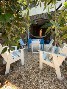 un grupo de sillas y mesas bajo un árbol en Casa belvedere Sa Costa, en Dorgali