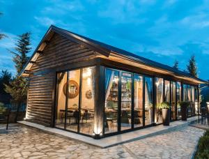une cabine avec de grandes baies vitrées sur un patio dans l'établissement Vila Helen, à Voskopojë
