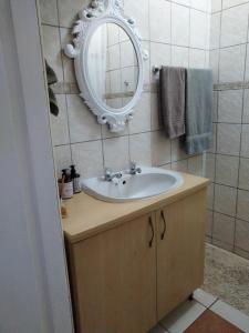łazienka z umywalką i lustrem na ścianie w obiekcie Sea Shell w mieście Morgan Bay