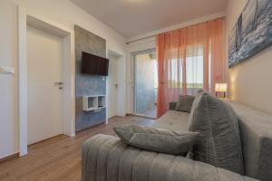 uma sala de estar com um sofá e uma televisão em La Prima Privlaka Luxury Apartments I em Privlaka
