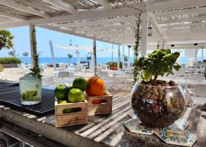 une table avec des fruits et un vase avec une plante sur la table dans l'établissement Le Mandrelle Beach Resort, à Amantea