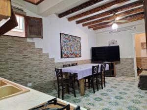 a dining room with a table and chairs and a television at Casa Geloso in Ustica