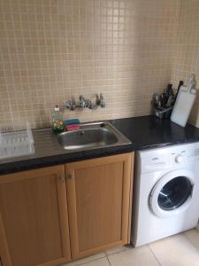 a kitchen with a sink and a washing machine at Panoramic Holidays - Standard 50 in Peyia