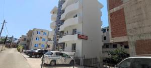 a white building with a car parked in front of it at Villa Alba Apartments in Dobra Voda